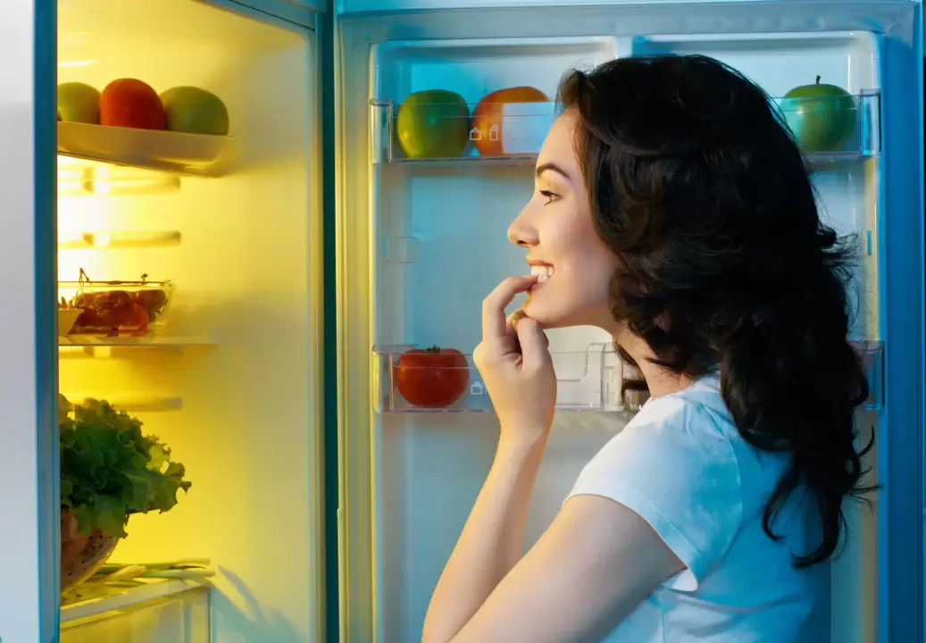 the girl looks at the refrigerator during rapid weight loss